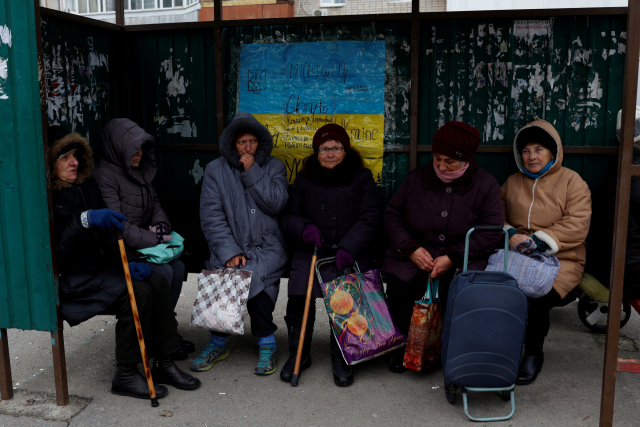 러시아군이 퇴각한 우크라이나 헤르손의 주민들이 22일(현지시간) 한 버스 정류장에서 구호품을 받기 위해 대기하고 있다. 로이터연합뉴스