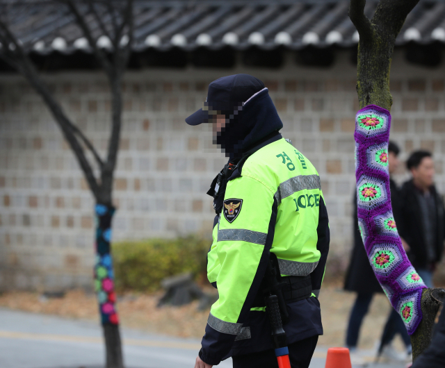 기상청이 30일부터 본격적인 한파를 예고했다. 사진은 28일 오후 서울 덕수궁에 배치된 경찰이 방한용품을 두른 채 근무하는 모습. 연합뉴스
