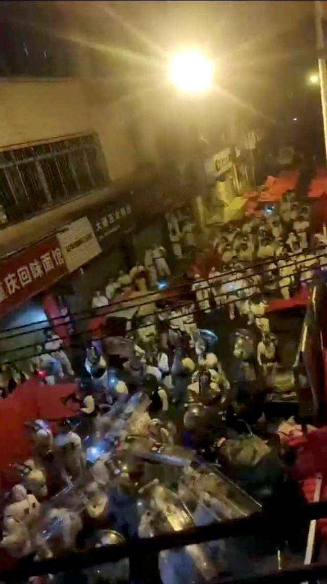 11월 30일 중국 광둥성 광저우에서 열린 코로나19 규제 시위 도중 보호복을 입은 경찰이 방패를 들고 이동하고 있다. 로이터연합뉴스