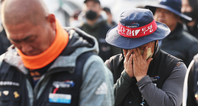 화물연대가 파업 철회를 결정한 9일 한 조합원이 경기도 의왕시 내륙컨테이너기지(ICD)에서 눈물을 닦고 있다. 연합뉴스