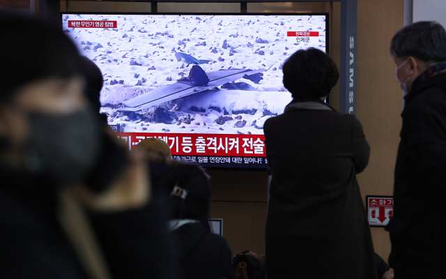 26일 서울역 대합실에서 시민들이 북한 무인기 영공 침범과 관련된 뉴스를 시청하고 있다. 연합뉴스