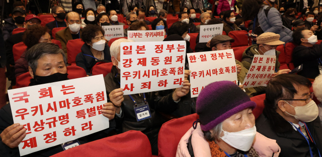 지난 12일 서울 여의도 국회 의원회관에서 열린 강제징용 해법 논의를 위한 공개토론회에서 참석자들이 피켓을 들고 있다. 연합뉴스