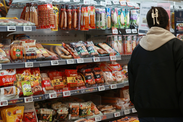 식품·프랜차이즈 업체들이 따라 제품 가격 인상을 예고한 가운데 한 소비자가 대형마트 식품코너를 지나가고 있다. 연합뉴스
