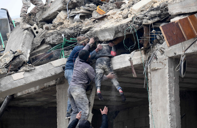튀르키예와 시리아를 강타한 규모 7.8의 강진 피해가 기하급수적으로 늘고 있다. 6일(현지시간) 시리아 알레포주 아프린시의 무너진 건물 사이에서 시민들이 매몰된 어린이를 구조하고 있다. AFP연합뉴스