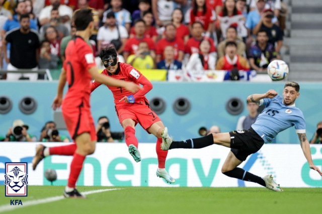 손흥민(왼쪽)이 우루과이와의 카타르 월드컵 조별리그 경기에서 슈팅하고 있다. KFA 제공