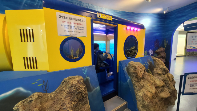잠수함 체험 시설이 설치된 해양생물테마파크 2층 해저탐험대 체험실에서 어린이들이 잠수함 체험을 하고 있다.