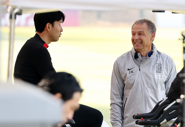 21일 파주 NFC(국가대표트레이닝센터)에 입소한 손흥민(왼쪽)이 훈련에 앞서 클리스만 감독과 대화하고 있다. 연합뉴스