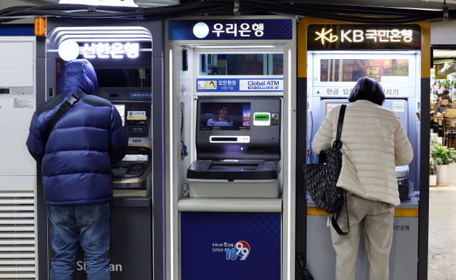시중은행의 대출·예금금리가 1년여 만에 모두 3%대로 하락한 것으로 나타났다. 시민들이 한 시장 내 식당가 앞에 설치된 은행 현금인출기(ATM)를 이용하고 있다. 연합뉴스