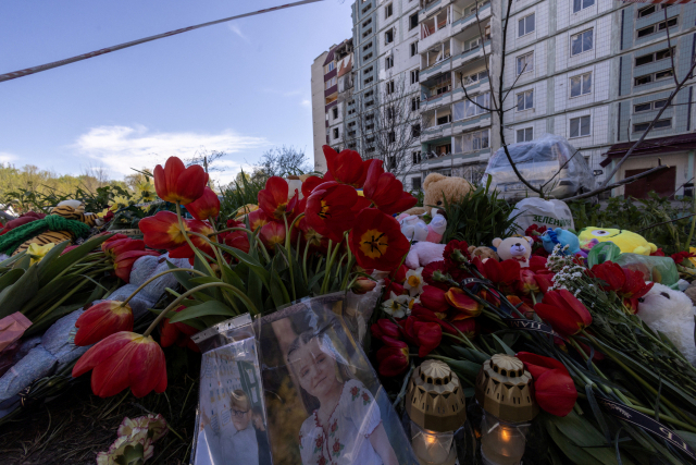 지난달 29일 우크라이나의 한 아파트 주변에 러시아의 미사일 공격으로 숨진 어린이들을 추모하는 사진과 꽃다발이 놓여 있다. 로이터연합뉴스