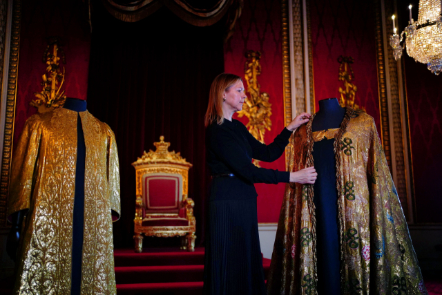 지난달 26일 영국 런던 버킹엄 궁전에서 영국 왕실재단 로얄 컬렉션 트러스트의 캐롤라인 드 기토 수석 큐레이터가 찰스 3세의 대관식 의상을 손질하고 있다. AFP연합뉴스