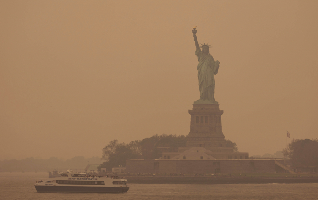 미국 뉴욕 자유의 여신상이 7일(현지 시간) 뿌옇게 변했다. 캐나다에서 시작한 산불 연기가 미국 동부까지 확산하자 미국 환경보호청(EPA)은 이날 대기질 경보를 발령했다. AP연합뉴스