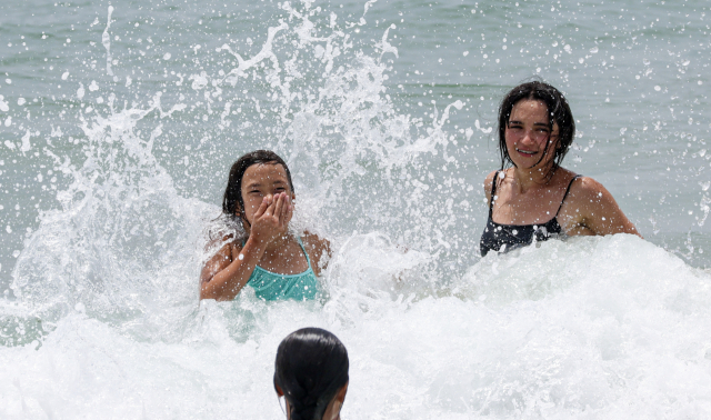 부산지역에 올해 첫 폭염주의보가 발효된 2일 부산 해운대해수욕장을 찾은 피서객들이 해수욕을 즐기며 더위를 식히고 있다.