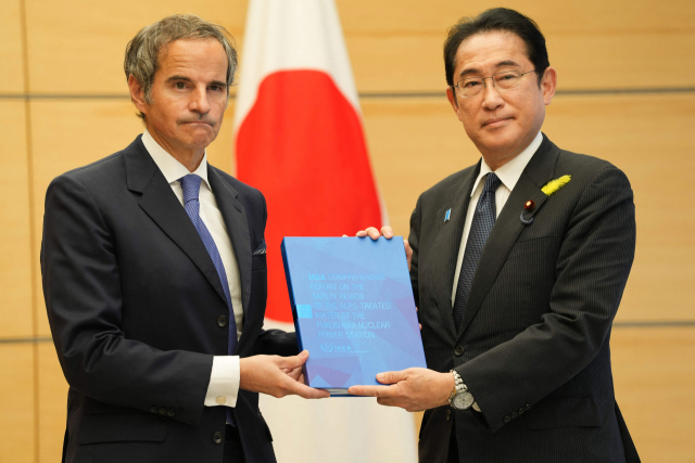 국제원자력기구(IAEA) 라파엘 그로시 사무총장(왼쪽)이 4일 일본 도쿄의 총리 관저에서 열린 기시다 후미오 일본 총리와의 회담에 앞서 IAEA 보고서를 전달하고 있다. AFP연합뉴스