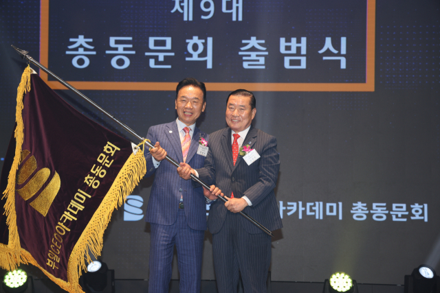 신한춘(오른쪽) 제9대 총동문회 회장이 최금식 전임 회장으로부터 회기를 전달받고 있다. 이재찬 기자