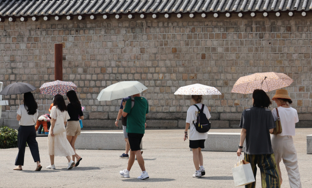무더위가 계속된 3일 서울 종로구 삼청동길에서 시민들이 강한 햇살에 양산을 쓰고 이동하고 있다. 연합뉴스