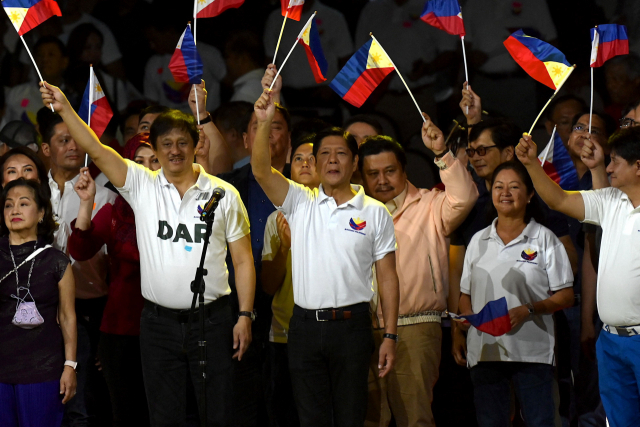 필리핀 대통령 페르디난드 마르코스 주니어(가운데)가 28일 수도 마닐라에서 지지자들과 함께 라이벌인 두테르테에 항의하는 표시로 필리핀 국기를 흔들고 있다. AFP연합뉴스