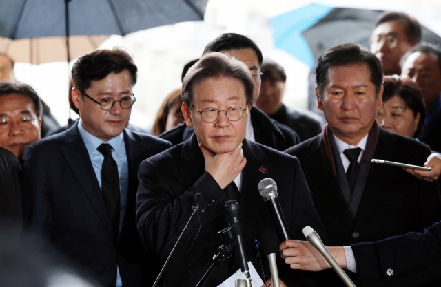 더불어민주당 이재명 대표가 5일 오전 광주 북구 국립 5·18 민주묘지를 참배한 뒤 목을 만지며 기자회견을 준비하고 있다. 연합뉴스