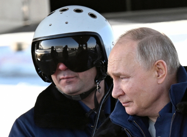 블라디미르 푸틴 러시아 대통령(오른쪽)이 22일 카잔을 방문해 핵무기 탑재 초음속 장거리 전략폭격기 투폴레프(Tu)-160M에 탑승하기 위해 준비하고 있다. 로이터연합뉴스