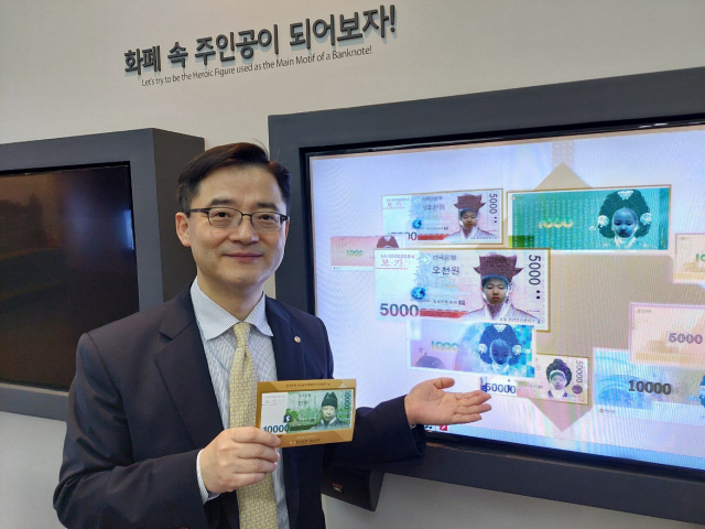 김정훈 한국은행 경남본부장이 화폐전시관에 마련된 ‘화폐 속 주인공이 되어보자’라는 코너에서 가상 지폐를 만드는 체험을 소개하고 있다.