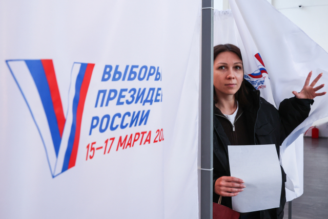 러시아 대통령 선거 첫날인 16일(현지시간) 한 여성이 투표소에서 투표소를 나서고 있다. 타스연합뉴스