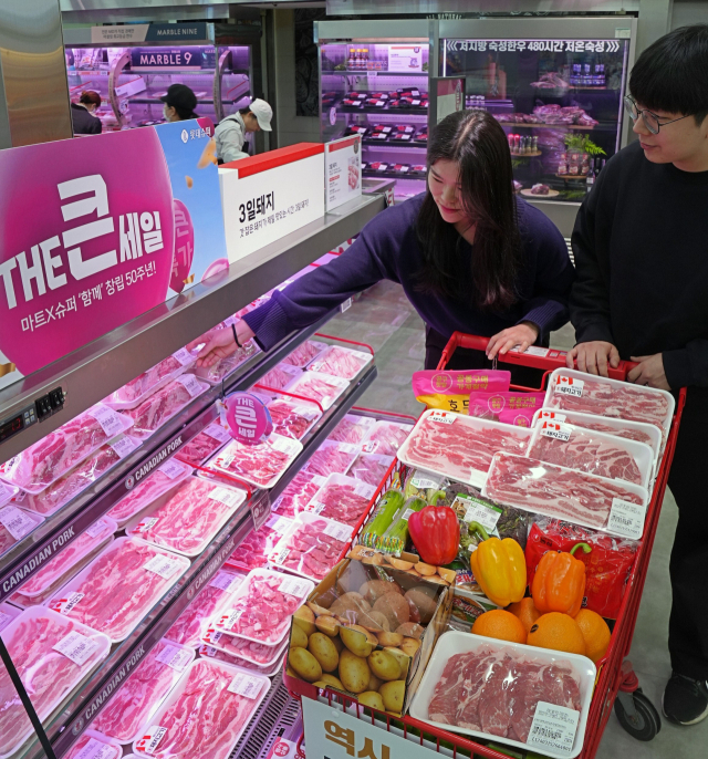 대형마트 3사가 최대 50%까지 먹거리 할인 행사를 진행한다. 롯데마트 제타플렉스 서울역점에서 캐나다산 삼겹살을 고객이 구매하고 있다. 롯데마트 제공