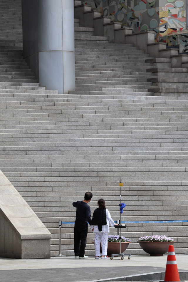 의대정원을 둘러싼 의정갈등이 이어지고 있는 가운데 21일 서울 한 대형병원에서 한 환자와 보호자가 계단 앞을 지나고 있다. 연합뉴스