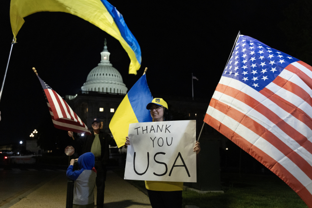 미국 상원이 이스라엘, 우크라이나, 대만에 대한 원조를 포함하는 950억 달러 규모의 국가 안보 추가 법안을 처리한 23일(현지시간) 우크라이나 지지자들이 미국 워싱턴DC 의사당 건물 밖에서 국기를 들고 있다. EPA연합뉴스