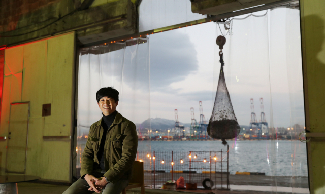 부산 영도에 버려진 물류창고가 지난해 4월 재생 문화공간 ‘끄티’로 재탄생했다. 김철우 대표가 ‘끄티’에서 환하게 웃고 있다. 김 대표 뒤로 보이는 조형물이 여상희 작가의 설치미술 작품이다. 이재찬 기자 chan@