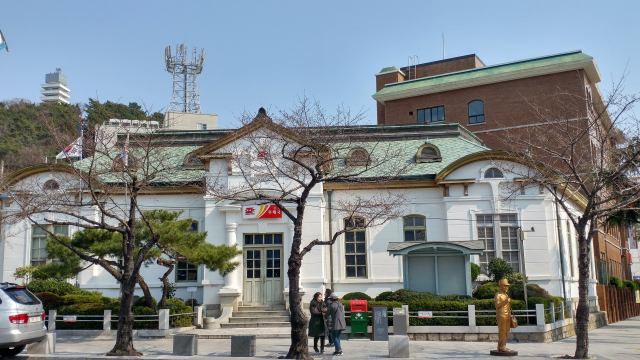 중원 로터리에서 바라본 진해우체국. 1912년에 러시아풍 건축 양식으로 지어진 건물로 현재까지도 원형이 잘 보존되고 있다. 왼쪽 뒤로 제황산공원과 진해탑이 보인다.