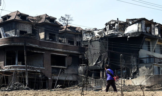 강원도 고성 산불 발생 나흘째인 7일 토성면 용촌리 마을에서 한 주민이 폐허가 된 건물을 바라보며 귀가하고 있다. 강원일보 제공