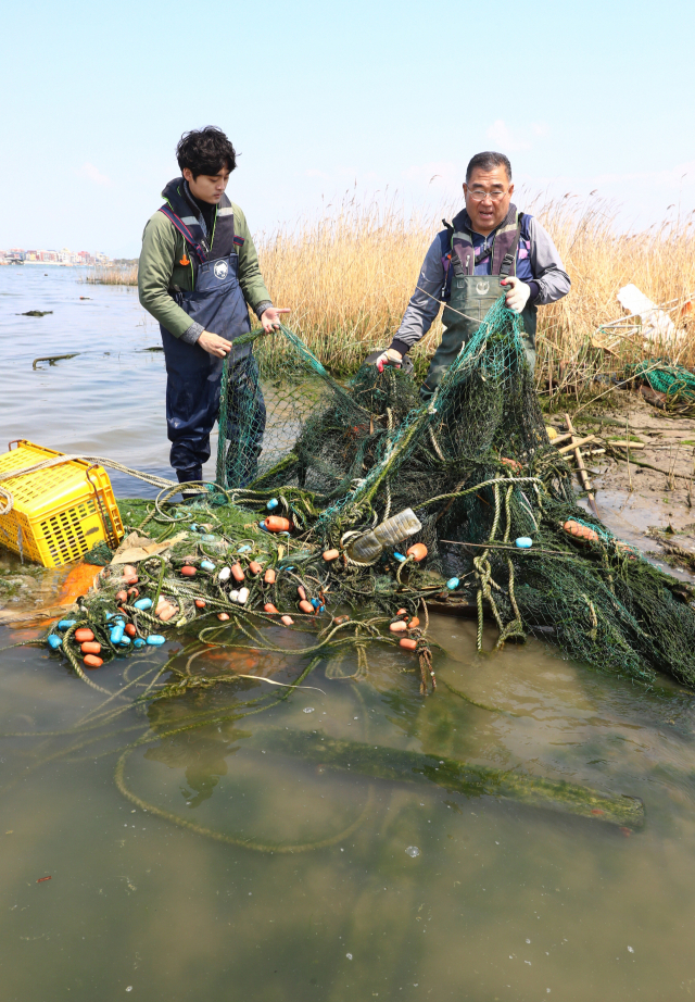 부산 낙동강 하구의 을숙도, 대마등, 도요등 등 모래톱과 갈대숲이 버려진 그물 등 폐어구로 몸살을 앓고 있다. 지난 12일 본보 곽진석 기자와 동행한 초록생활의 백해주(오른쪽) 대표가 을숙도 남단에서 폐그물을 들어보이고 있다. 정종회 기자 jjh@