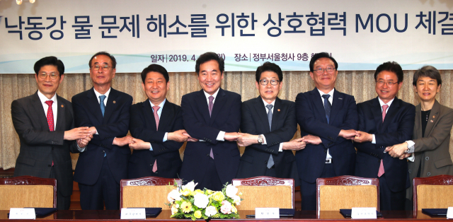 이낙연 국무총리가 29일 정부서울청사에서 낙동강 물 문제 해소를 위한 업무협약 체결식에 참석해 기념 촬영을 하고 있다. 왼쪽부터 노형욱 국무조정실장, 장세용 구미시장, 권영진 대구시장, 이 총리, 조명래 환경부 장관, 송철호 울산시장, 이철우 경북도지사, 정재숙 문화재청장. 연합뉴스