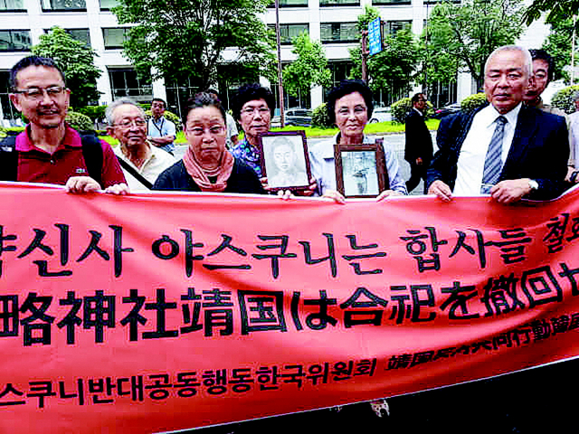 지난 2014년 야스쿠니 신사 합사 취소 소송 공판이 열린 도쿄 지요다구의 도쿄지방재판소 앞에서 원고들이 변호사, 일본 내 지원단체 관계자 등과 함께 유족의 사진과 항의 문구가 적힌 현수막을 들고 있다. 연합뉴스