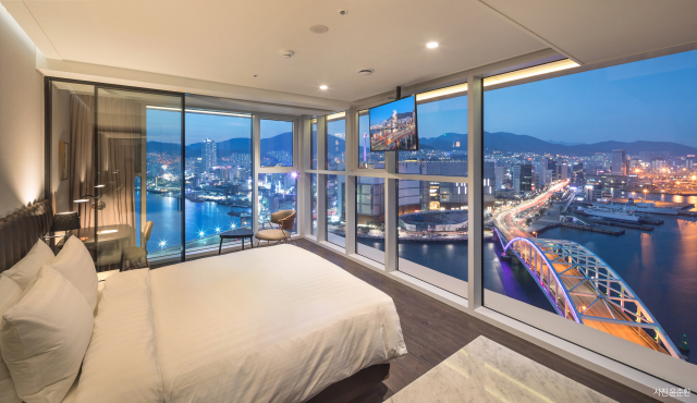 부산 영도구 봉래동 라발스호텔이 우수한 입지와 차별화한 식음료 매장, 현대적인 시설과 매력적인 원도심 야경 조망 등으로 국내외 호캉스족들 사이에서 인기 호텔로 자리매김하고 있다. 사진은 양면 개방형 통유리창을 통해 파노라마 오션 뷰를 즐길 수 있는 ‘코너 디럭스 룸’ 내부 모습. 라발스호텔 제공