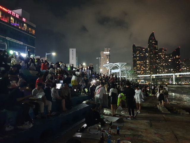 7일 오전 1시께 부산 수영구 민락동 민락수변공원. 가로등 13개가 모두 꺼져도 시민들이 자리를 뜨지 않은 채 공원을 가득 메우고 있다.