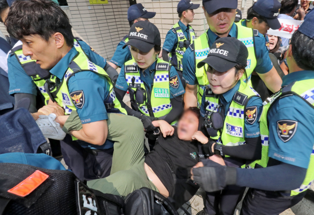 22일 오후 부산 동구 초량동 일본영사관에 진입해 반일 투쟁 시위를 벌이던 대학생 6명이 경찰에 연행되고 있다. 이들은 이날 오전 11시부터 일본 영사관 안 도서관에 신분증을 제출하고 미리 들어가 있다가 오후 2시 30분께 영사관 마당으로 뛰어나가 ‘주권침탈 아베규탄’ 플래카드에 페트병을 달아 밖으로 던진 혐의를 받고 있다. 김경현 기자 view@