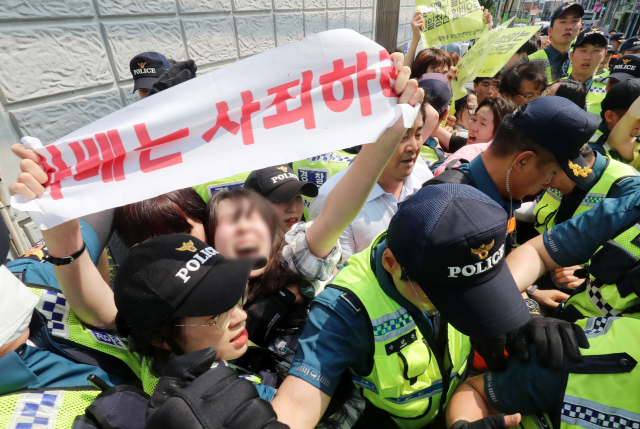 22일 오후 부산 동구 초량동 일본영사관에 진입해 반일 투쟁 시위를 벌이던 대학생 6명이 경찰에 연행되고 있다. 이들은 이날 오전 11시부터 일본 영사관 안 도서관에 신분증을 제출하고 미리 들어가 있다가 오후 2시 30분께 영사관 마당으로 뛰어나가 ‘주권침탈 아베규탄’ 플래카드에 페트병을 달아 밖으로 던진 혐의를 받고 있다. 김경현 기자 view@