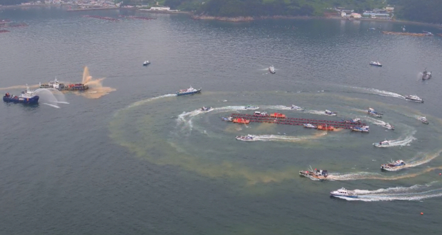 적조 경보가 발령된 경남 남해안에서 황토를 실은 선박들이 가두리양식장 주변에 몰려온 적조 방제 작업을 벌이고 있다. 경남도 제공