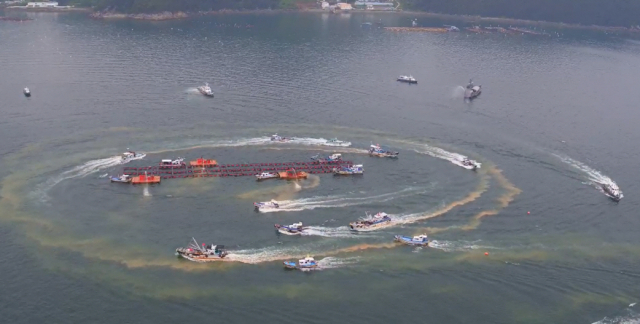 적조 경보가 발령된 경남 남해안에서 황토를 실은 선박들이 가두리양식장 주변에 몰려온 적조 방제 작업을 벌이고 있다. 경남도 제공