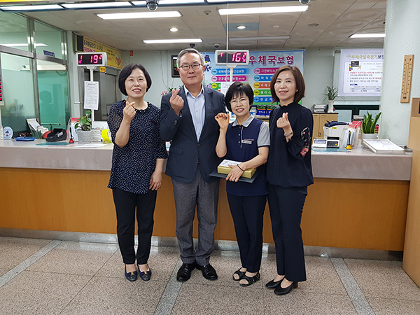 표창장 수여 기념사진_왼쪽에서 두 번째 김성칠 청장, 왼쪽에서 세 번째 김삼희 주무관. 부산지방우정청 제공.