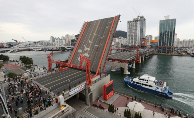7일 오후 관광객들이 지켜보는 가운데 부산 영도대교가 들리고 있다. 최근 안전점검에서 영도대교 도개 때 기준치 7배에 달하는 진동 수치가 확인돼 안전에 대한 우려가 나오고 있다. 영도대교 도개는 매일 오후 2시에 진행된다. 이재찬 기자 chan@