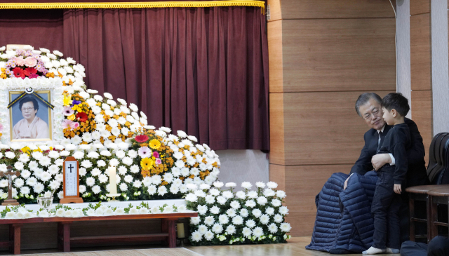 문재인 대통령이 30일 오전 부산 남천성당에 마련된 모친 고 강한옥 여사의 빈소에서 손주와 대화하고 있다. 청와대 제공