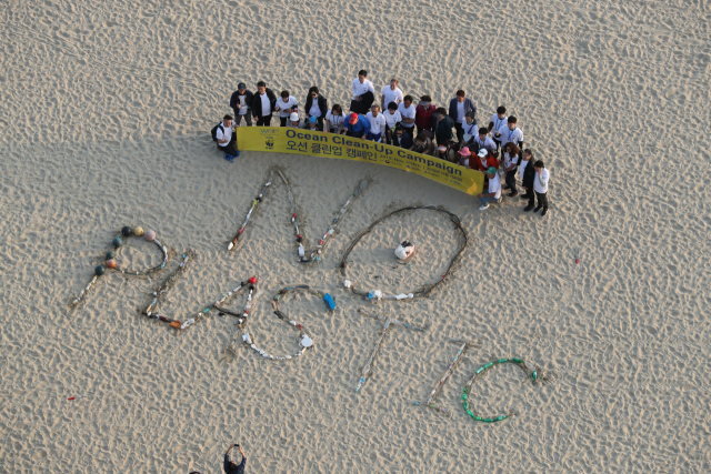1일 오션 클린업 캠페인 참가자들이 구덕포 해안에서 수거한 쓰레기로 해운대 백사장에 ‘플라스틱 그만(NO PLASTIC)’을 썼다. 강선배 기자 ksun@busan.com