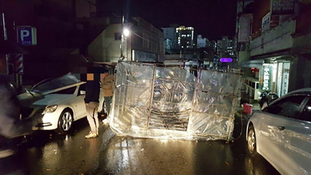 지난 10일 오후 부산 금정구 한 주택 옥상에 설치된 비닐하우스 구조물이 강한 바람에 날려 인근 도로에 떨어져 있다. 부산경찰청 제공