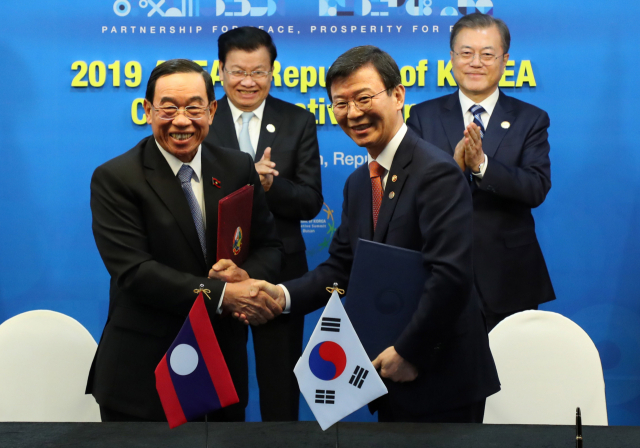 문성혁 해양수산부 장관과 라오스 분찬 신타봉 공공사업교통부 장관이 26일 문재인 대통령과 통룬 시술릿 총리가 참석한 부산 한 호텔에서 항만운영 정보화 사업협약식을 하고 있다. 연합뉴스