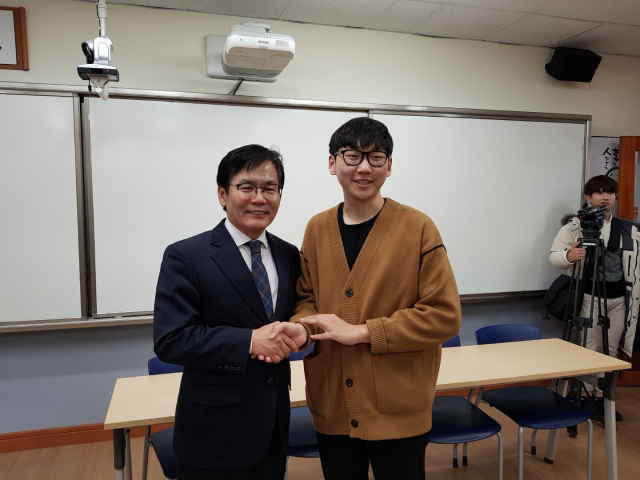 경남 김해외고 송영준 군이 강무석 교장선생님의 손을 잡고 환하게 웃고 있다. 백남경 기자