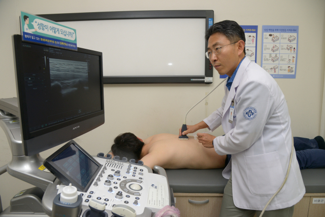 박대현 부산백병원 정형외과 교수가 요통 환자의 허리 통증을 확인하기 위해 초음파검사를 하고 있다. 부산백병원 제공