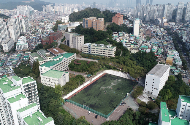 부산외대 우암동 부지 개발 계획이 확정됐지만 향후 세부 계획 마련과 철탑마을 원주민들의 호응 여부 등이 과제로 남게 됐다. 부산외대 우암동 부지 전경. 부산일보DB