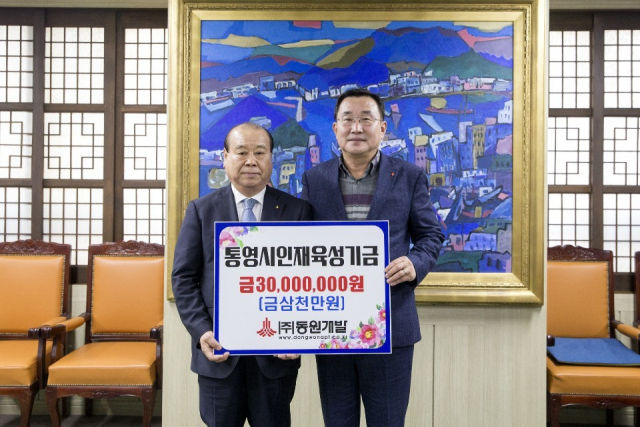 지난 24일 장복만 (주)동원개발 회장을 대신해 통영시를 찾은 이성휘 부사장(왼쪽)이 강석주 통영시장에게 장 회장이 준비한 인재육성기금 3000만 원을 전달했다. 통영시 제공