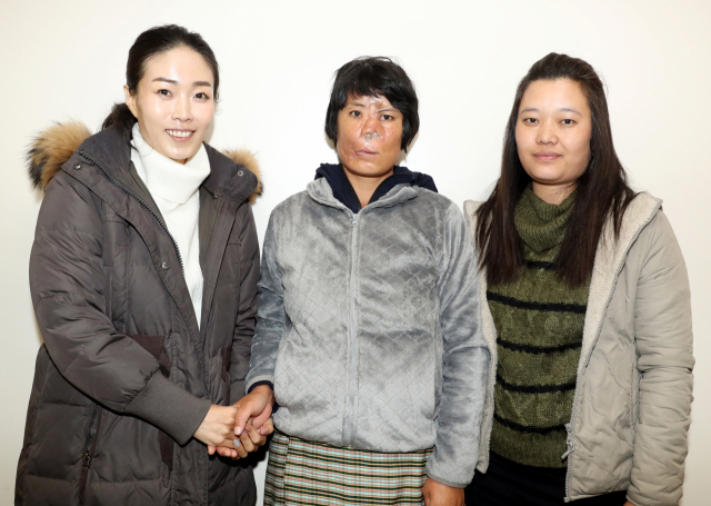 히말라야 야생곰에게 습격 받아 부상 당한 타시 데마(36·가운데) 씨. 16일 부산 서구 동아대병원에서 치료비를 지원한 조마리아 셰프(39·왼쪽), 조카 초키(30) 씨와 기념 사진을 찍고 있다. 강원태 기자 wkang@